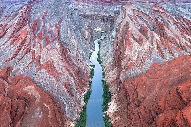A captivating aerial shot of the winding Rio San Juan flowing through the vibrant red rock formations in Utah, USA, showcasing nature's artistic sculpting