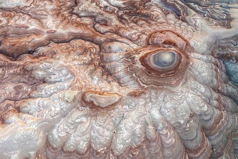 This aerial image captures the mesmerizing abstract patterns of bentonite sandstone in Utah, USA. The swirling textures and vivid colors showcase the region's unique geological beauty