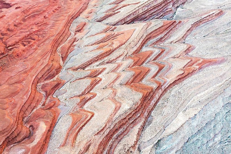 Colorful sediment patterns unfold in an aerial view of the canyon landscape near the San Juan River, showcasing Utah's unique geological beauty