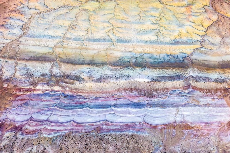 Explore the captivating textures of Vermilion Cliffs National Monument in Arizona. This aerial view reveals colorful desert layers, showcasing the area's natural geological artistry
