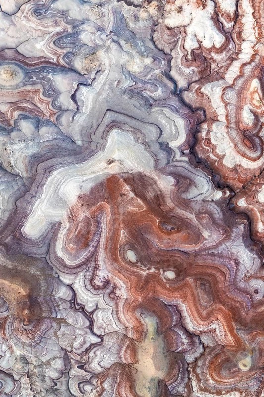 Stunning aerial view of Utah's bentonite sandstone formations. The vibrant layers create a mesmerizing, abstract geological pattern in a unique natural landscape