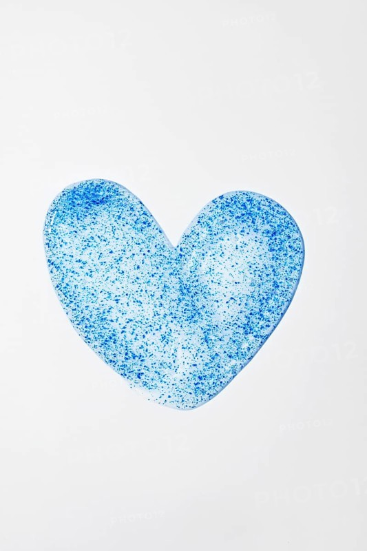 A close-up of face scrub in a heart shape, featuring blue micro-exfoliating particles Ideal for promoting skincare routines, beauty treatments, and product aesthetics