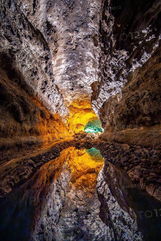 Lava tunnel, illuminated lava cave with perfect reflection in an underground lake, Cueva de los Verdes, Lanzarote, Canary Islands, Spain
