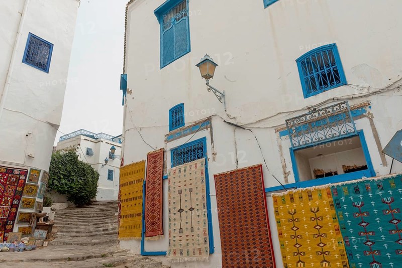 May 17th 2024. Sidi Bou Said, Tunisia. Tourist souvenir rugs hanging outside a store in the narrow streets of Sidi Bou Said, a pretty village near the Tunisian ruins of Carthage, Tunis, Tunisia