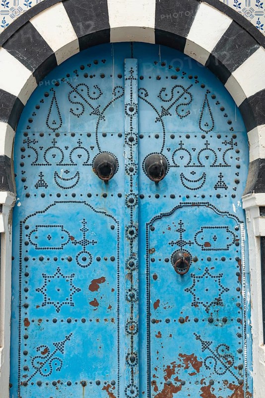 Detailed design of a traditional blue door in the Tunisian cliff top village of Sidi Bou Said, overlooking historical Carthage and the Gulf of Tunis. Tunisia