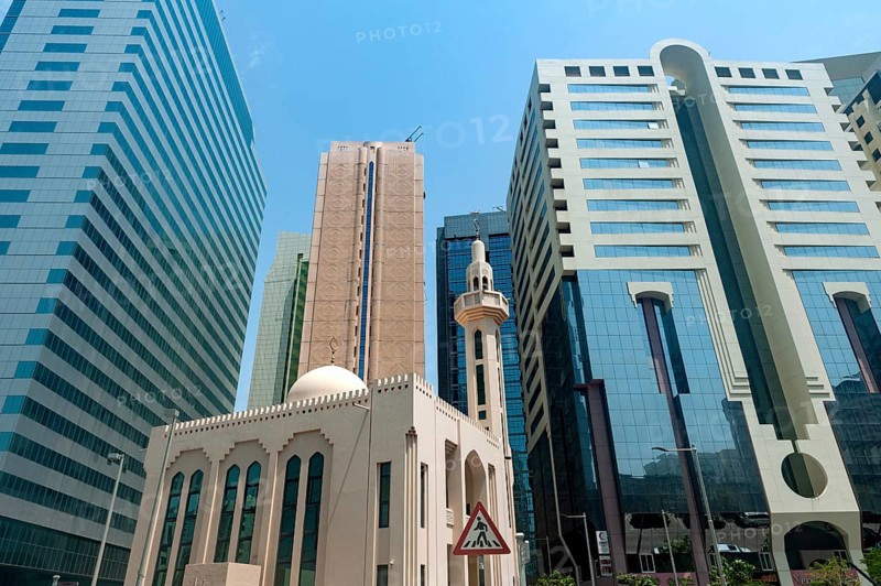 Abu Dhabi, United Arab Emirates. June 23rd 2019 A mosque among modern glass fronted office buildings, typical architecture in the city of Abu Dhabi, United Arab Emirates, Middle East