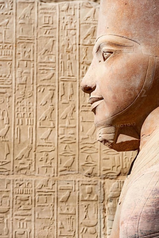 2000 year old Portrait Statue of Ancient Egyptian Pharaoh Queen Hatshepsut, against Hieroglyphic detail, Karnak Temple, Luxor, River Nile, Egypt