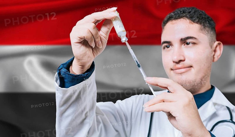 Doctor holding syringe on Yemen flag background. Medical professional holding syringe with Yemeni flag in the background