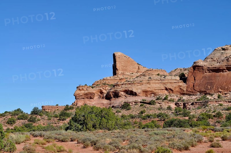Large, towering rock in a sparsely vegetated desert landscape, Canyonlands National Park, Island in the Sky, Utah, USA