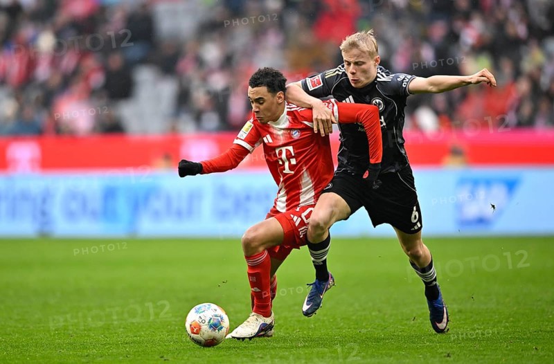 Duel, action Oscar Hojlund Eintracht Frankfurt SGE (06) against Jamal Musiala FC Bayern Munich FCB (10) rain, Football Bundesliga, Allianz Arena, Munich, Bavaria, Germany