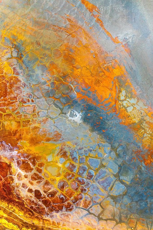 Vivid multicolored mud texture showcasing an abstract pattern A blend of earthy tones like orange, blue, and brown creates a captivating natural design