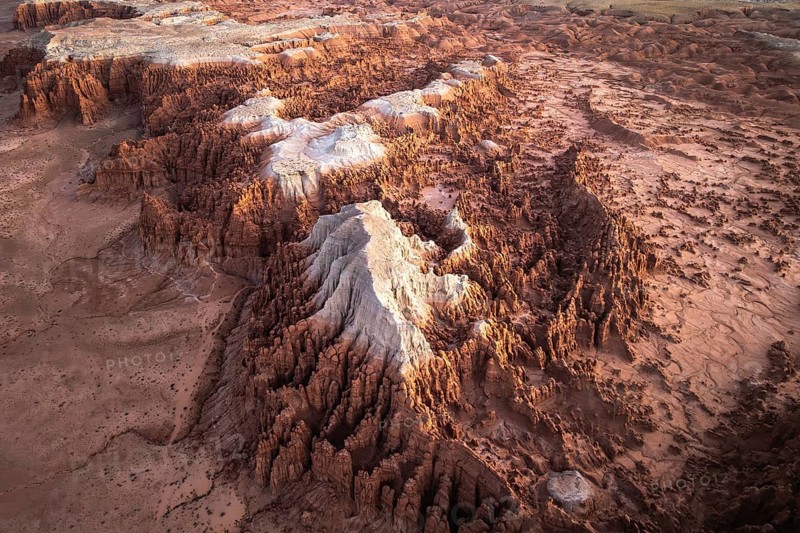 Aerial shot capturing the intricate rock formations and textured landscape of Goblin Valley State Park in Utah, highlighting varied hues and geological features