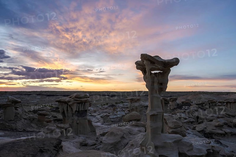 Stunning rock formations under a vibrant sunset sky in Bisti De-Na-Zin Wilderness, New Mexico The unique landscape showcases extraordinary geological features