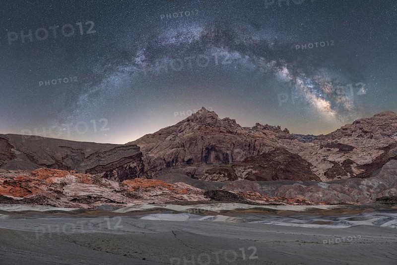 A breathtaking panoramic view of the Milky Way arching over the rugged landscapes of the Utah desert, under a star-studded night sky