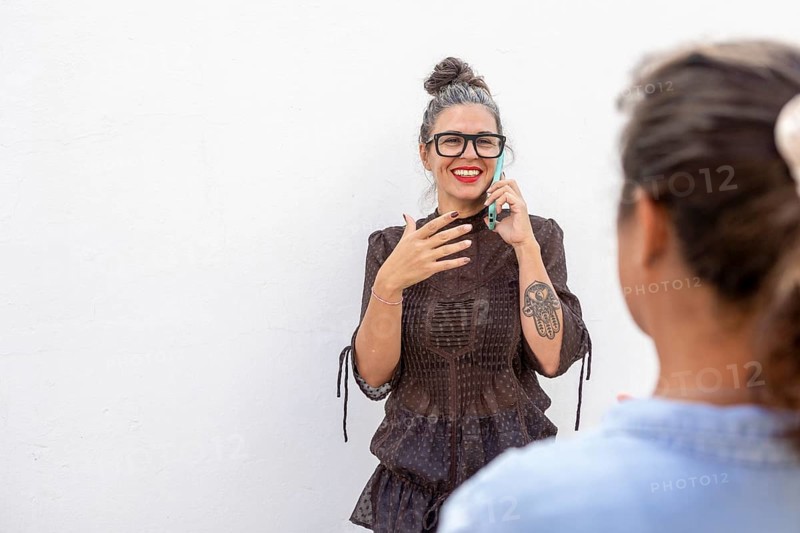 A smiling woman using sign language during a lesson She engages with another person, demonstrating expressive communication Ideal for education and inclusivity themes