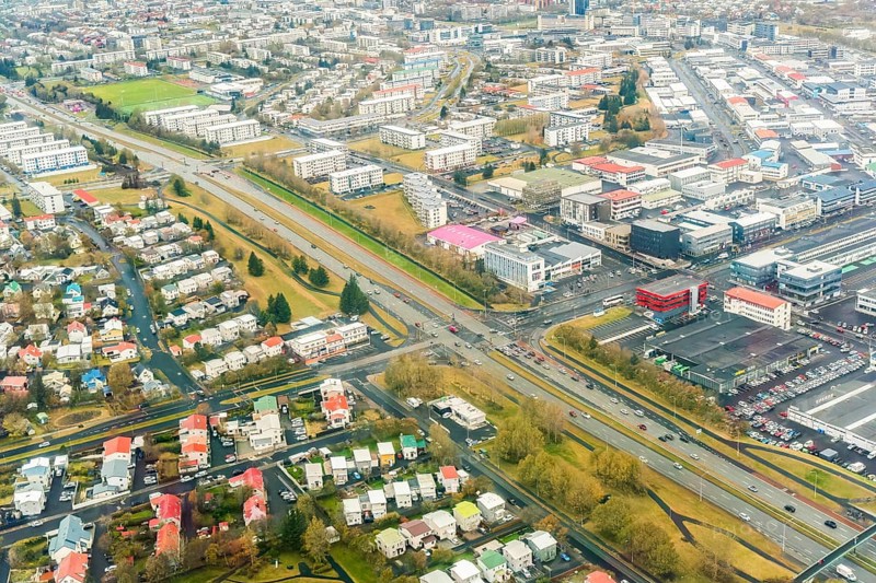 Aerial image of Reykjavik, Iceland, displaying a detailed urban layout with dense housing and structured road systems, highlighting the unique city planning amidst natural landscapes