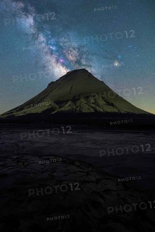 A striking view of an Icelandic mountain silhouetted against the vibrant Milky Way The serene night captures the magic of Northern nights in a breathtaking landscape