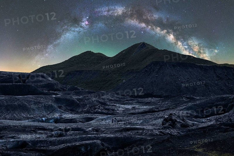 Captivating Icelandic terrain under a stunning starry sky The Milky Way arcs gracefully above, illuminating the rugged landscape with an ethereal glow