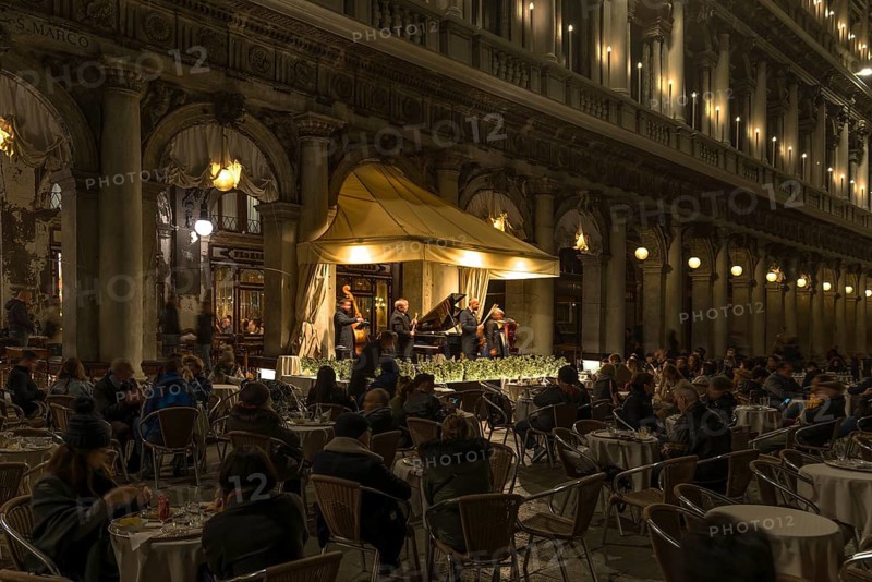 Music orchestra playing in front of the historic Café Florian on St. Mark's Square in the evening, Venice, Veneto, Italy