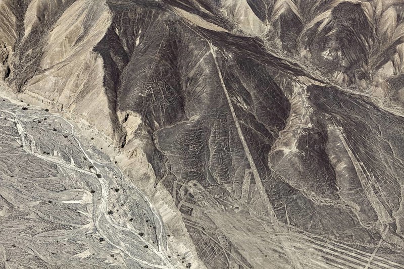 A mountainous country with a recognizable line pattern flying over the desert, the geoglyphs and images in the desert near Nasca and Palpa in Peru
