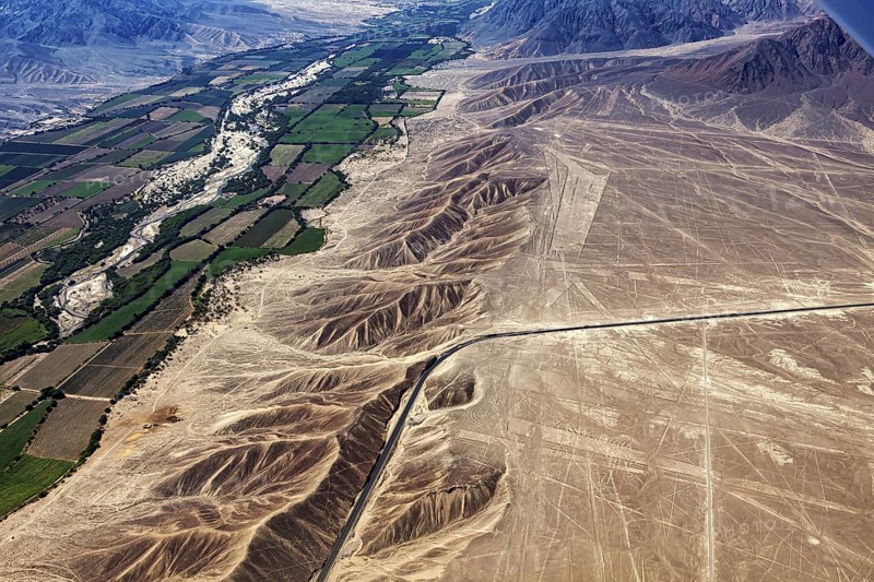 Contrasting landscape with dry desert, green fields and geoglyphs, the geoglyphs and drawings in the desert near Nasca and Palpa in Peru