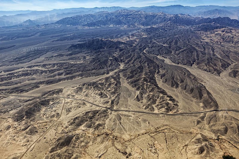 Wide and dry desert landscape with flat mountains and secluded roads, the geoglyphs and images in the desert near Nasca and Palpa in Peru