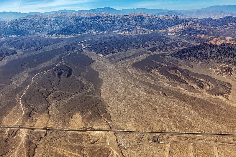 Extensive desert landscape with a long straight road, captured from above, The desert landscape near Nasca in Peru