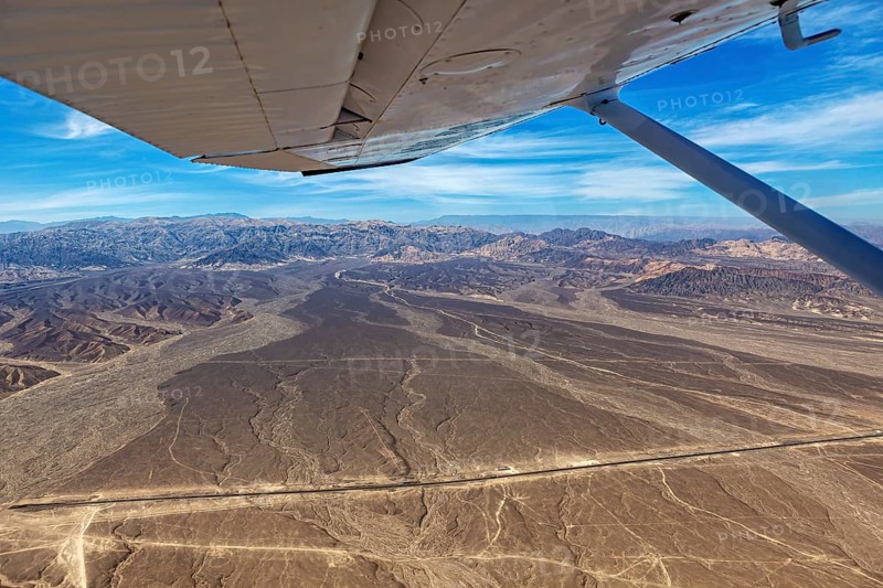 Desert landscape with a view from an airplane, mountains and a clear blue sky, The desert landscape near Nasca in Peru