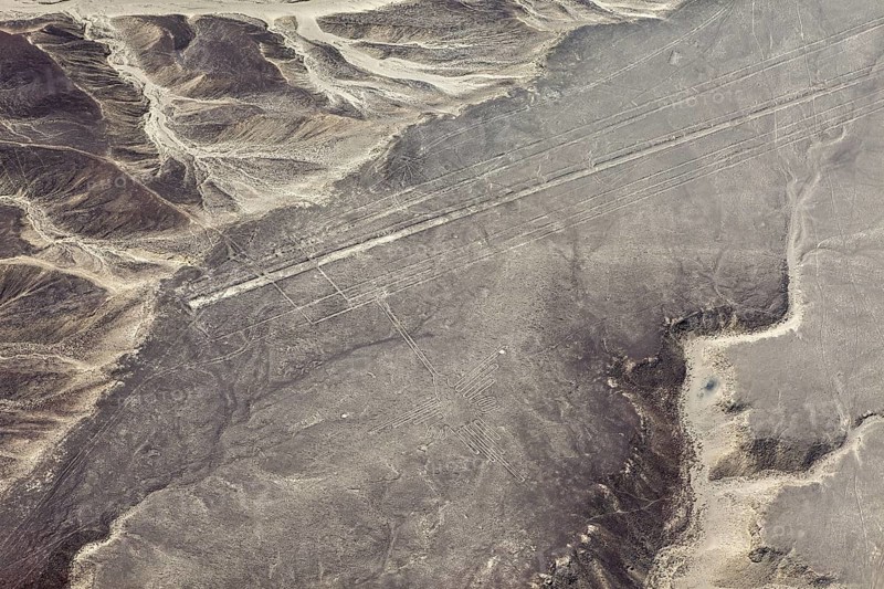 Lines and geoglyphs over an infinite desert plain, taken from lofty heights, with mountain slopes, the geoglyphs and images in the desert near Nasca and Palpa in Peru