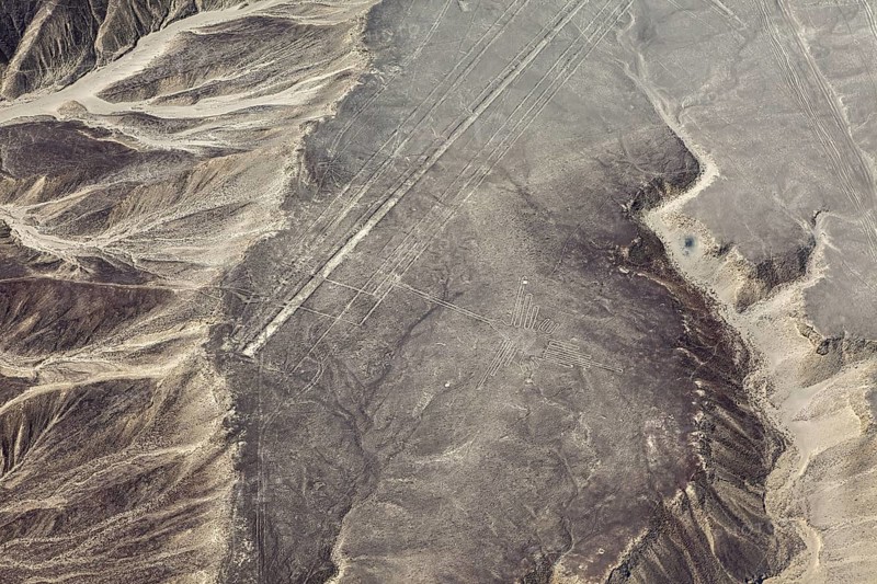 Desert area with linear geoglyph patterns, captured from the air, with mountains in the background, the geoglyphs and images in the desert near Nasca and Palpa in Peru