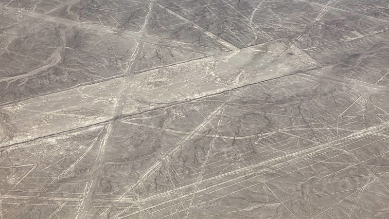 Aerial view of the Nazca lines in a barren desert landscape with geometric patterns, the geoglyphs and images in the desert near Nasca and Palpa in Peru