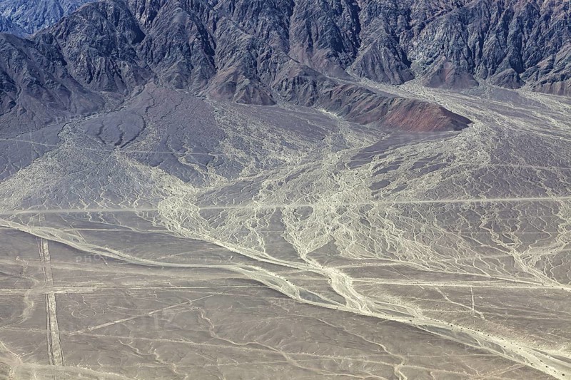 Erosion-prone desert landscape with rough mountain structures in the background, The desert landscape near Nasca in Peru