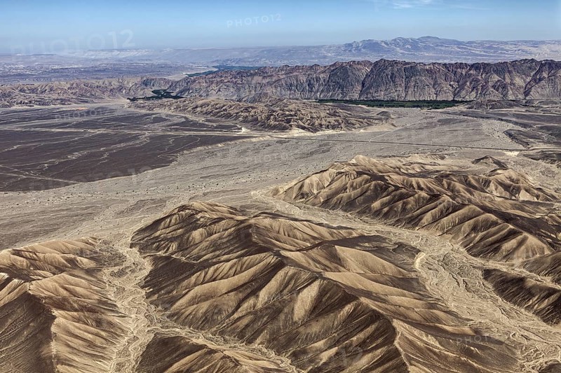 Wide desert landscape with sandy mountains and clear skies that accentuate aridity and vastness, The desert landscape near Nasca in Peru