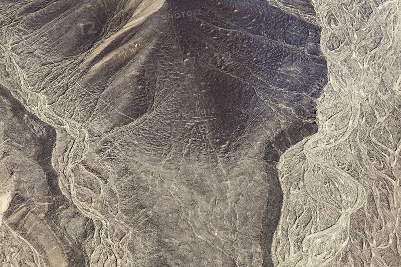 Geoglyphs and natural elevations in a dry, vast desert landscape, The geoglyphs and images in the desert near Nasca and Palpa in Peru