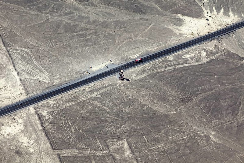 Aerial view of a road surrounded by geoglyphs and desert lines, the geoglyphs and images in the desert near Nasca and Palpa in Peru
