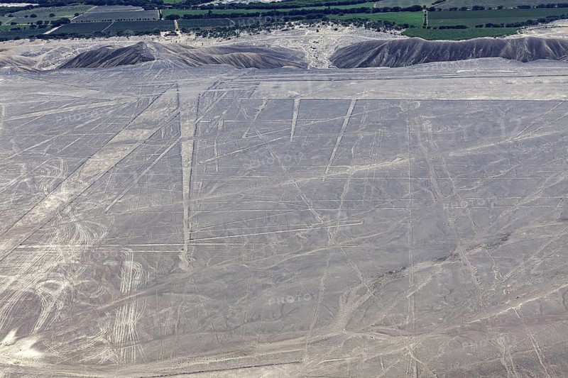 View of the desert with visible geoglyphs, fields and mountains lying in the distance, the geoglyphs and images in the desert near Nasca and Palpa in Peru