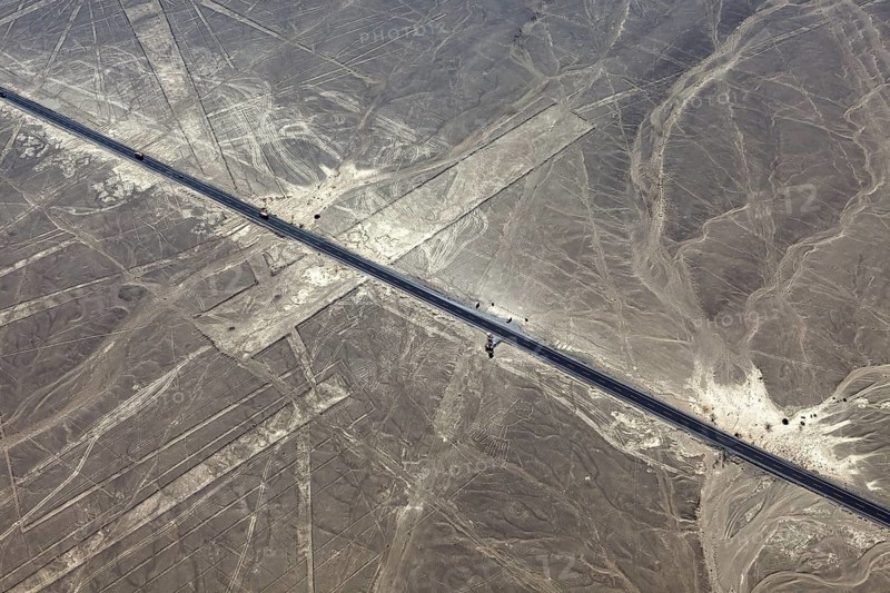 Aerial view of a road running through a desert landscape with lines, the geoglyphs and images in the desert near Nasca and Palpa in Peru