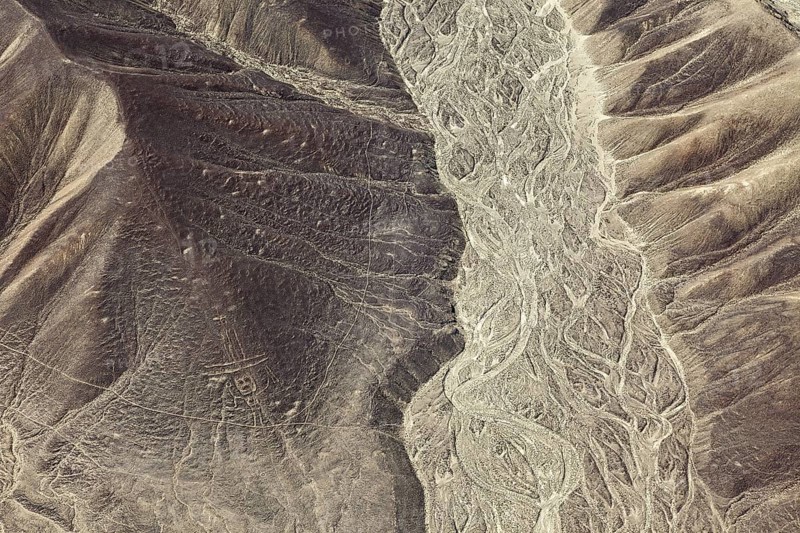 Aerial view of a hilly desert landscape with old patterns, geoglyphs and paintings in the desert near Nasca and Palpa in Peru