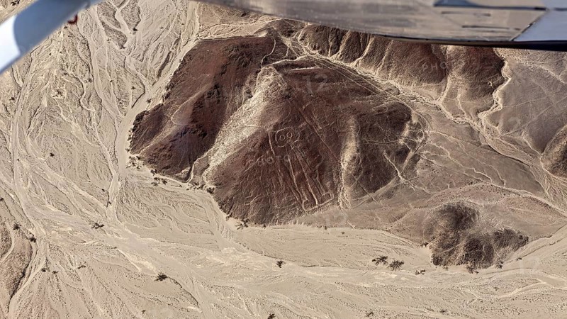 Aerial view of a desert landscape with geoglyphs and sandy hills, the geoglyphs and images in the desert near Nasca and Palpa in Peru
