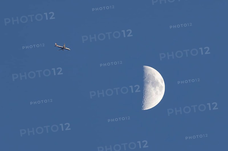 Airbus commercial passenger airliner jet aircraft of British airways in flight with the moon in the background, England, United Kingdom