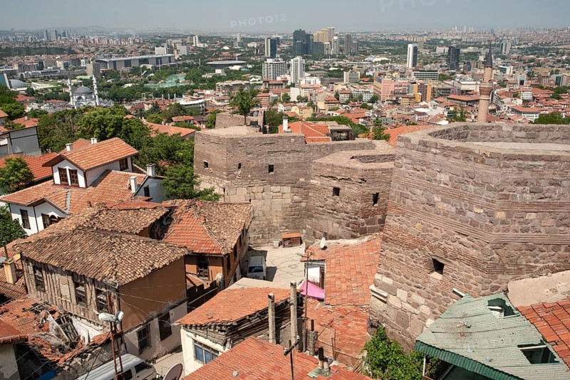 A panoramic view of old and modern houses from the ancient city walls of Ankara castle, Anatolia, Turkey. Visitors to Ankara castle enjoy a panoramic view of the modern Turkish capital from the old town city walls. Ankara, Turkey