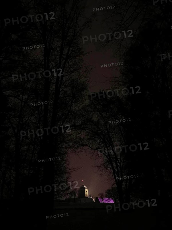 Building hidden in the dark, dimly lit Rosenberg Fortress surrounded by trees, Kronach, Frankenwald nature park Park
