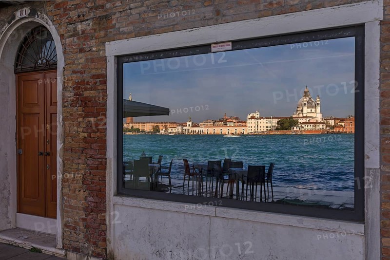 Santa Maria Salute is reflected in a shop window on the island of Guidecca, Venice, Veneto, Italy