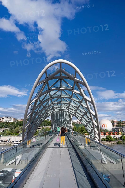 Tbilisi, Georgia. September 12th 2025 Tourists cross The Bridge of Peace over the Kura River also known in Georgia as the Mtkvari River in the Georgian capital, Tbilisi, Georgia