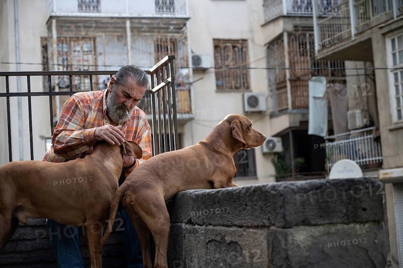 Tbilisi, Georgia. September 12th 2025. A local Georgian man with his pet dogs in the streets of Tbilisi Old Town, Georgia