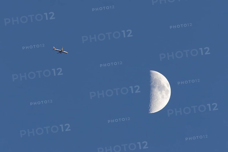 Airbus commercial passenger airliner jet aircraft of British airways in flight with the moon in the background, England, United Kingdom