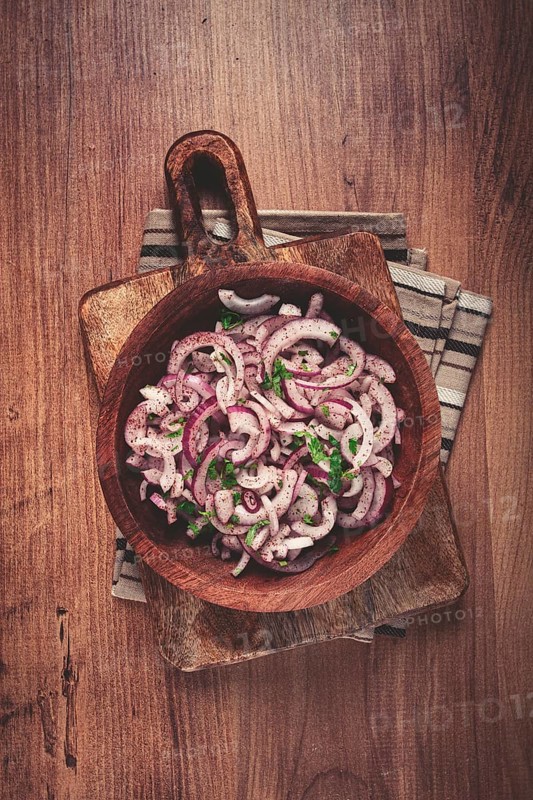 Chopped red onion, with sumac and herbs, in a bowl, pickled Spanish onion, close-up, top view