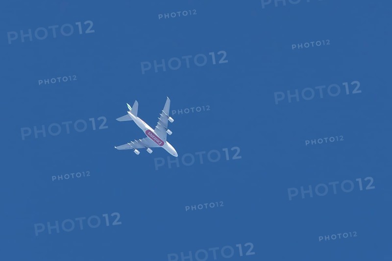 Airbus A380 commercial passenger airliner jet aircraft of Emirates airlines flying in a blue sky, England, United Kingdom