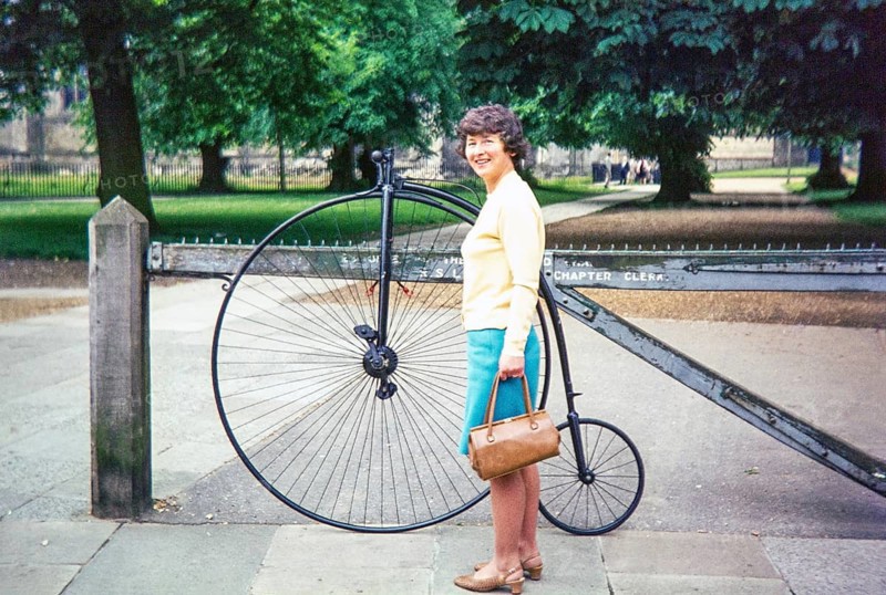 Woman standing by penny-farthing bicycle, Durham Cathedral, Durham, England, UK 1970s