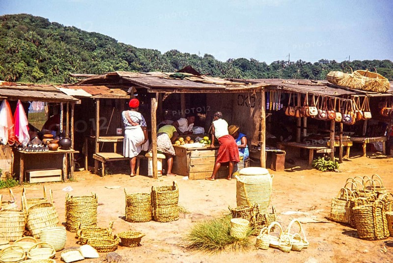 Woman at local market selling fruit and handicrafts including baskets, leather handbags and pottery, South Africa, Africa, 1979